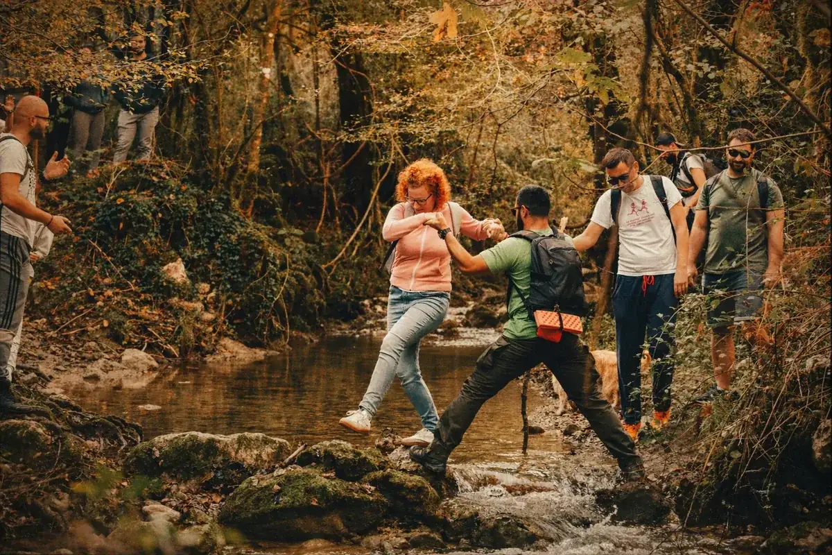Coinis team hiking across a stream