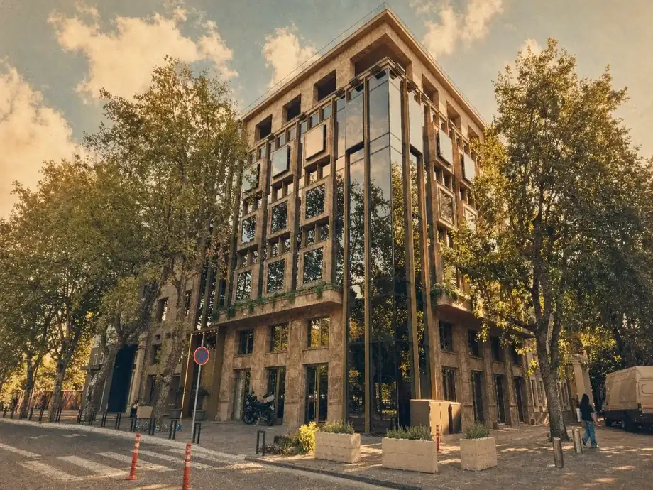 Street-level view of Coinis HQ building corner with mirrored windows at golden hour