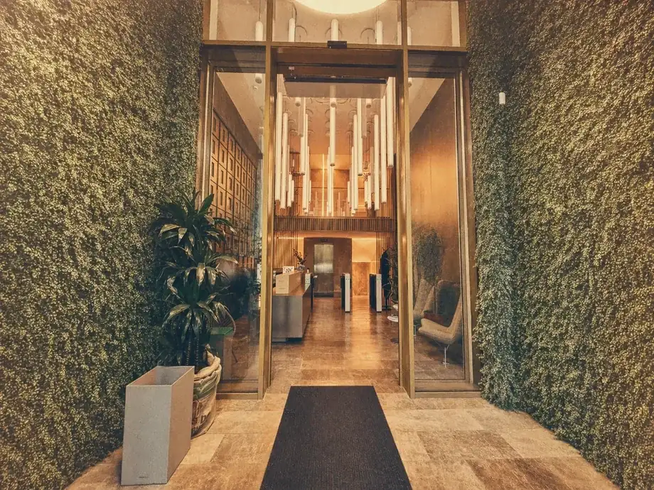 Entrance lobby with living moss walls and glass doors at Coinis HQ