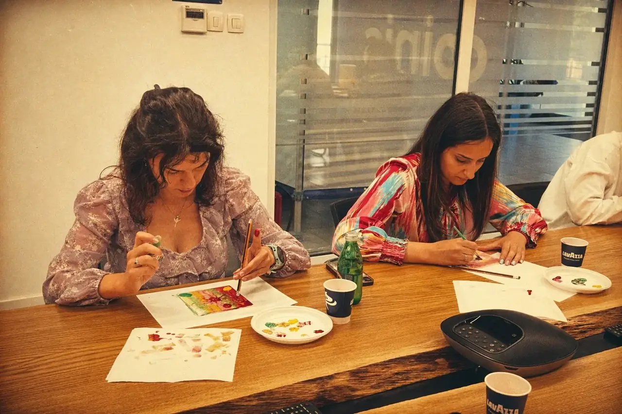 Coinis teammates painting together during a creative office session