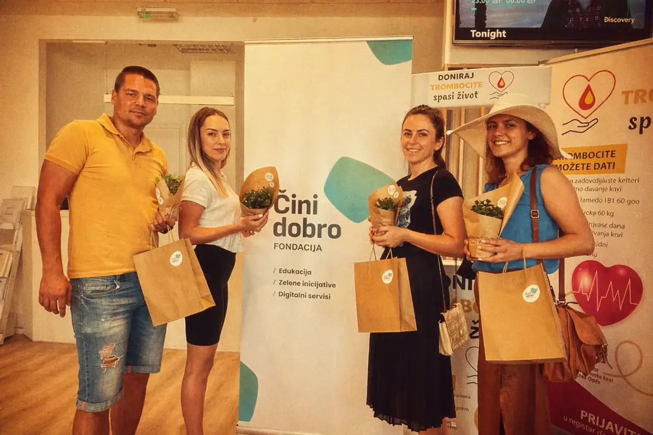 Coinis teammates smiling while holding potted plants in the office