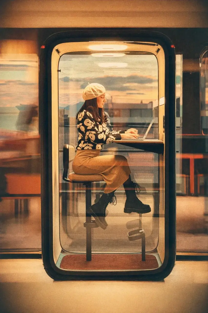 Coinis teammate taking a focus call inside an acoustic phone booth