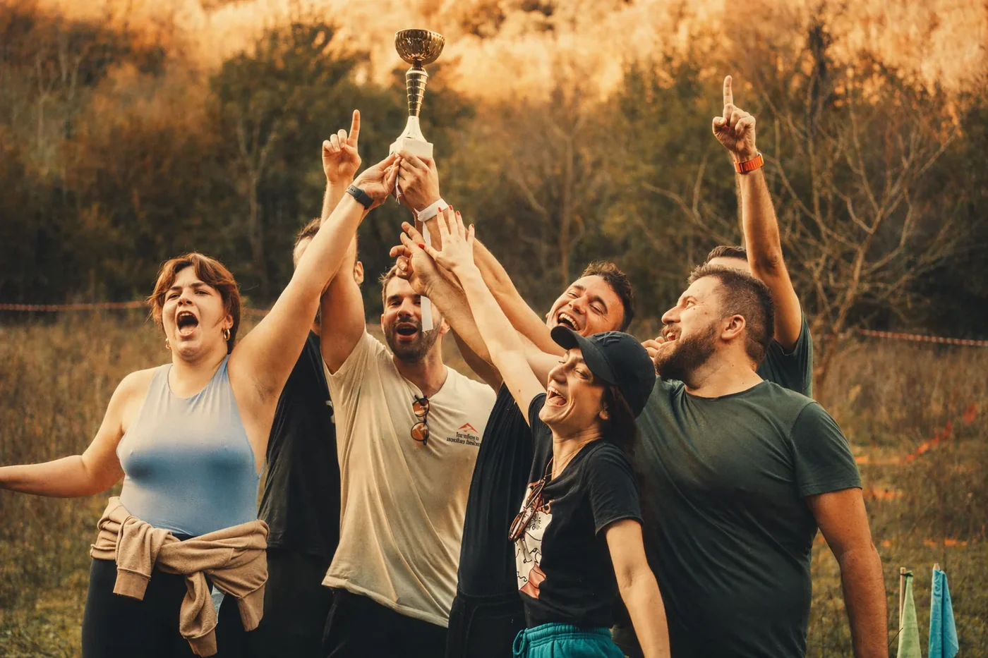 Coinis team raising a trophy at an outdoor team event