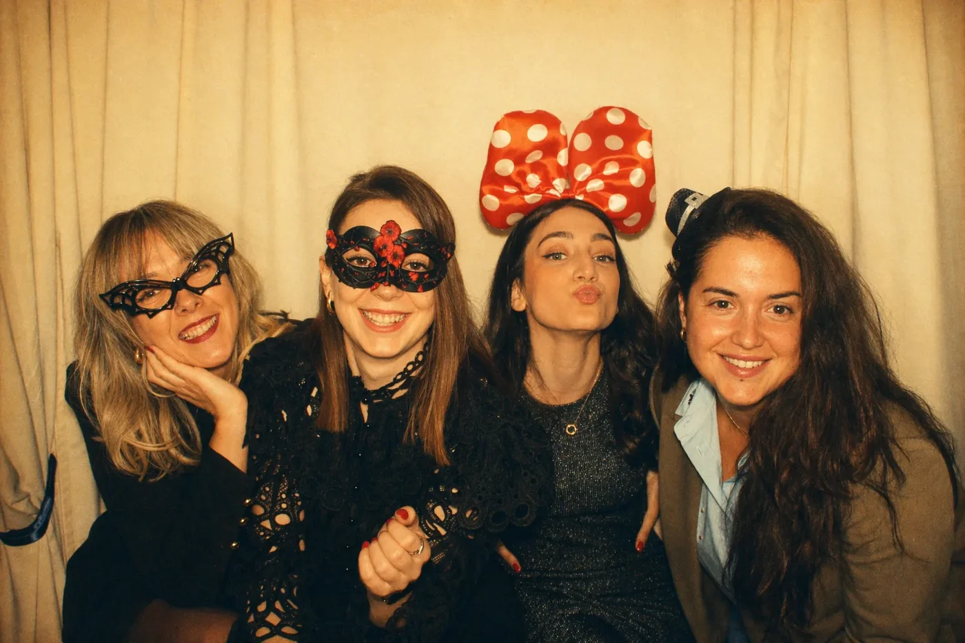 Two Coinis teammates posing with hats and masks in a photo booth