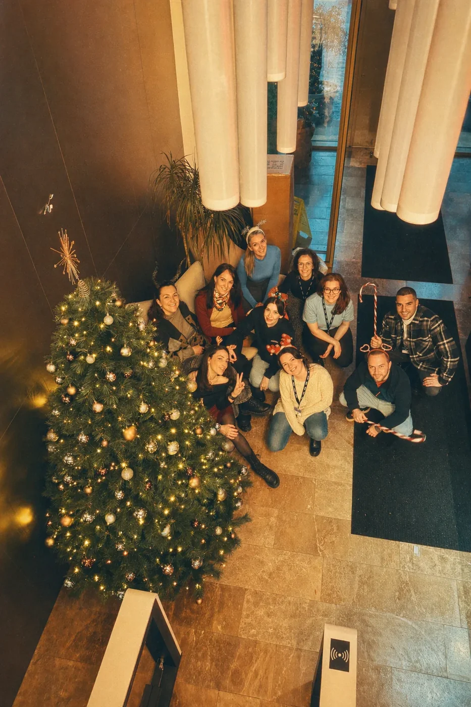 Coinis team gathered around a Christmas tree at a holiday party
