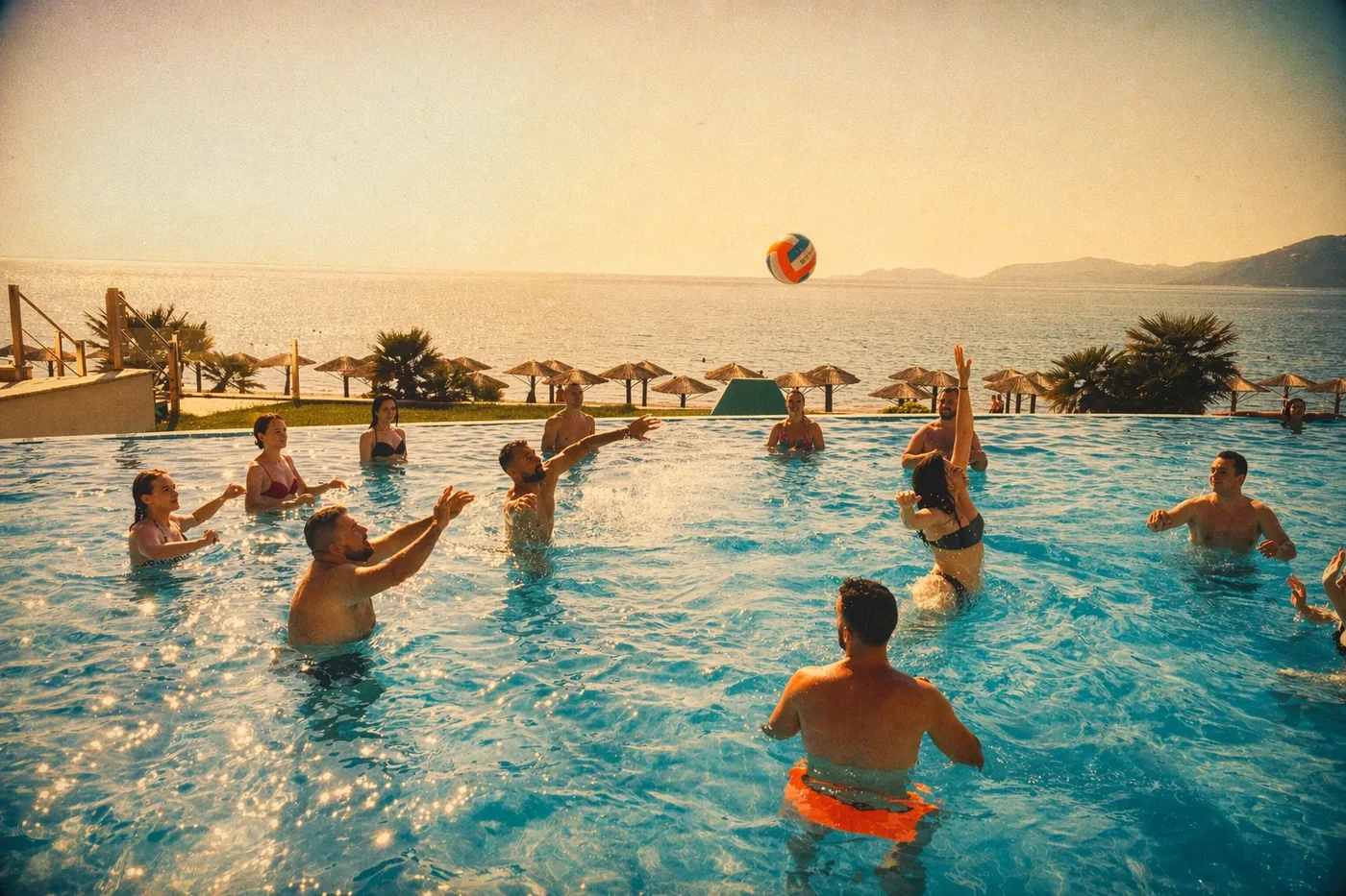 Coinis teammates playing volleyball in the pool on a sunny day